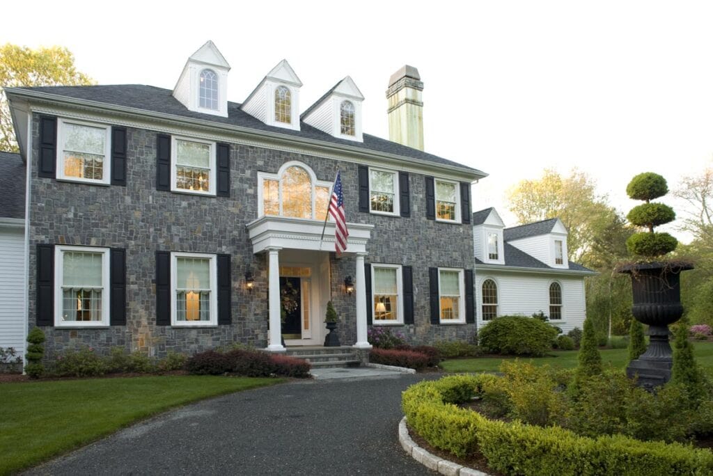 North Kingstown Estate exterior with stone facade, black shutters, and landscaped front yard