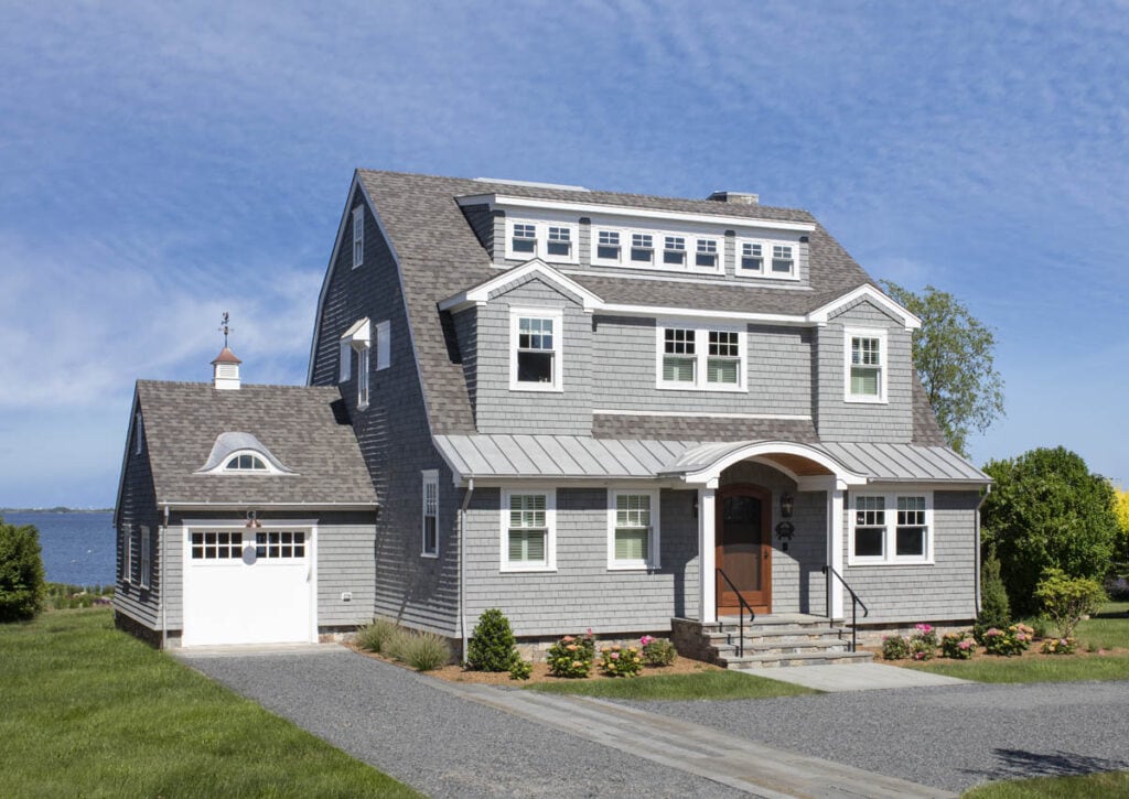 Ninigret Pond Beach Home exterior with gray shingle siding, arched entry porch, and attached garage