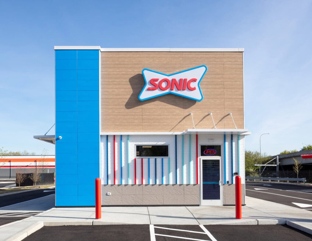 Modern Sonic drive-thru building with vibrant blue, red, and white exterior, showcasing professional commercial construction by Deslandes Construction Inc.