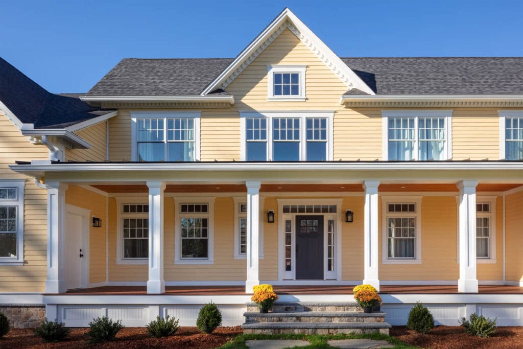 Exeter Rural Farm House exterior with yellow siding, covered front porch, and white columns