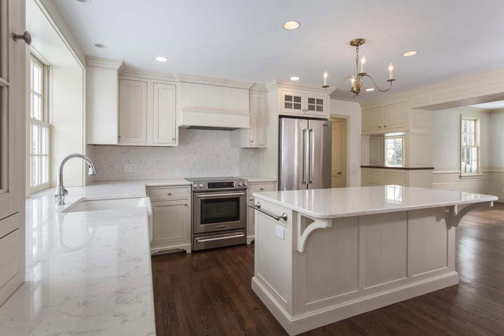 Barrington Historic Colonial Renovation kitchen with white cabinetry, large island, and stainless steel appliances