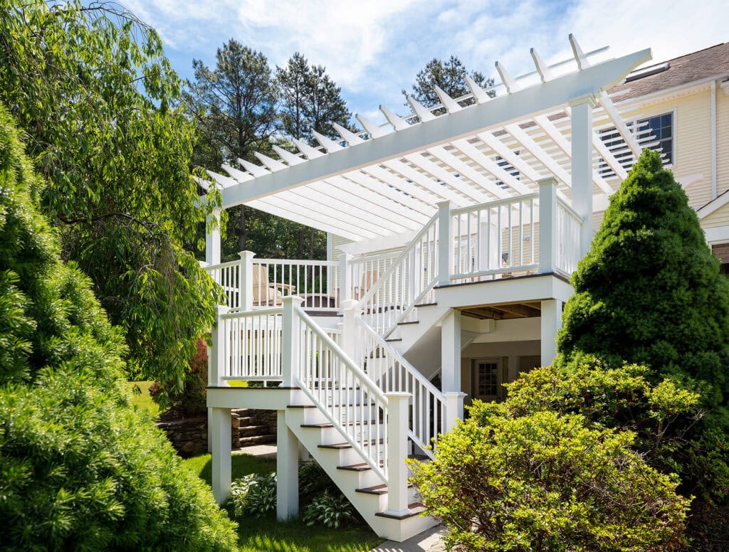 Burrillville Colonial deck renovation with white pergola, stairs, and railings