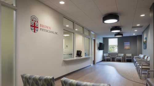Modern medical office waiting room with comfortable chairs, reception window, and calming artwork, showcasing professional healthcare interior design by Deslandes Construction Inc.