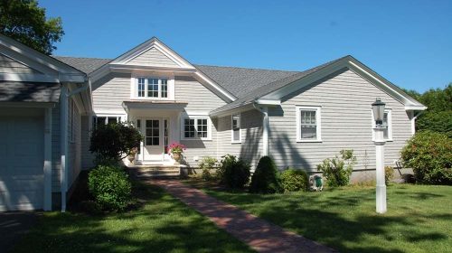 Tiverton Ranch remodel showing updated exterior for an open floor plan renovation with cathedral ceilings, new fireplace, and marble master bathroom