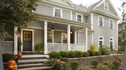Barrington Federal Colonial exterior after renovation designed around a historic brick fireplace, featuring a farmer’s porch and updated facade