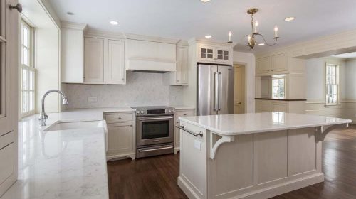 Barrington Historic Colonial Renovation kitchen with white cabinetry, large island, and stainless steel appliances