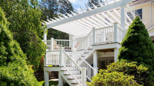 Burrillville Colonial deck renovation with white pergola, stairs, and railings